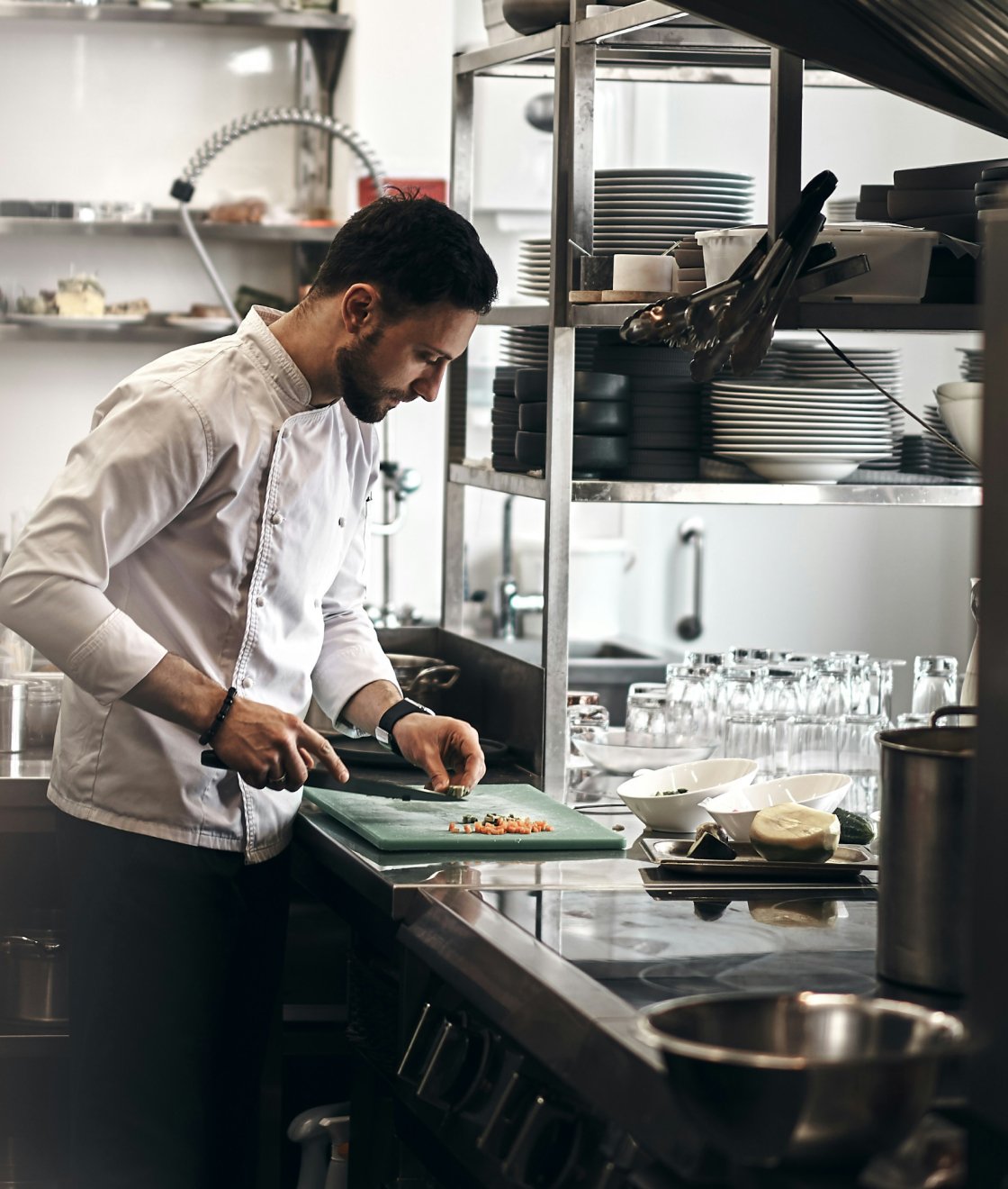 A professional chef working in the kitchen of a high-end restaurant, demonstrating expertise in culinary arts.