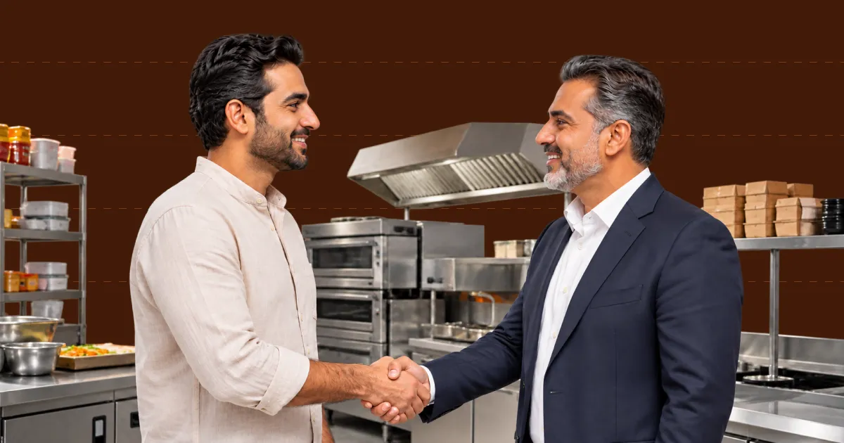 Food brand owner and kitchen operator shaking hands inside a commercial kitchen
